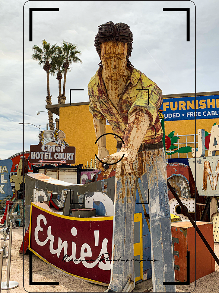 Verwitterte Figur eines Mannes zwischen historischen Reklameschildern im Neon Museum in Las Vegas.